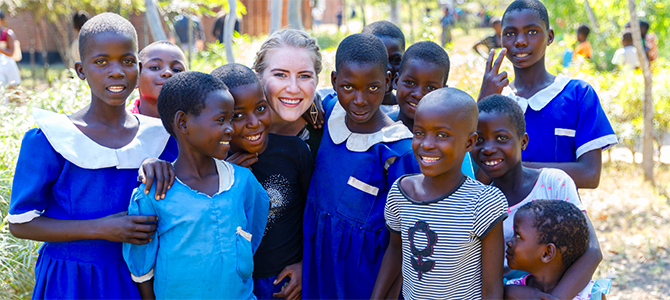 Nu Skin Employee Emily Sander poses for a picture with a group of children from Malawi.