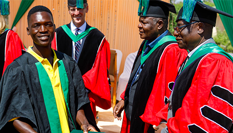 School of Agriculture for Family Independence (SAFI) students in their graduation gowns receive their diplomas.