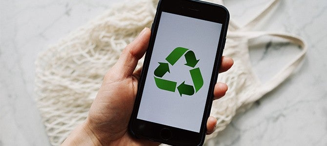 someone holding a smartphone with the recycling logo