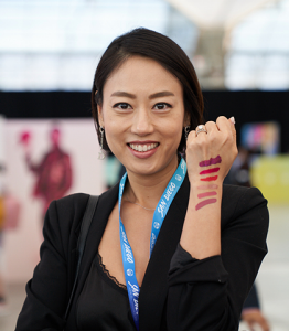 Girl with lipstick swatches on her arm.