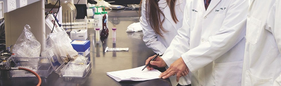 Nu Skin scientists taking notes as they conduct research.