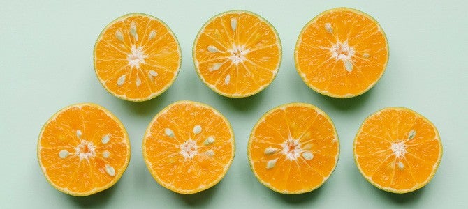 orange halves laid on mint green background
