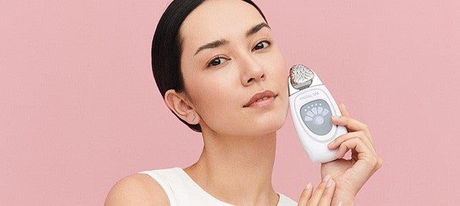 woman holding nu skin facial spa skin care device