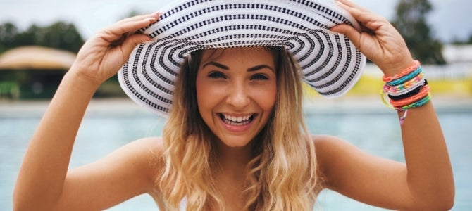 girl at a pool wearing a sun hat