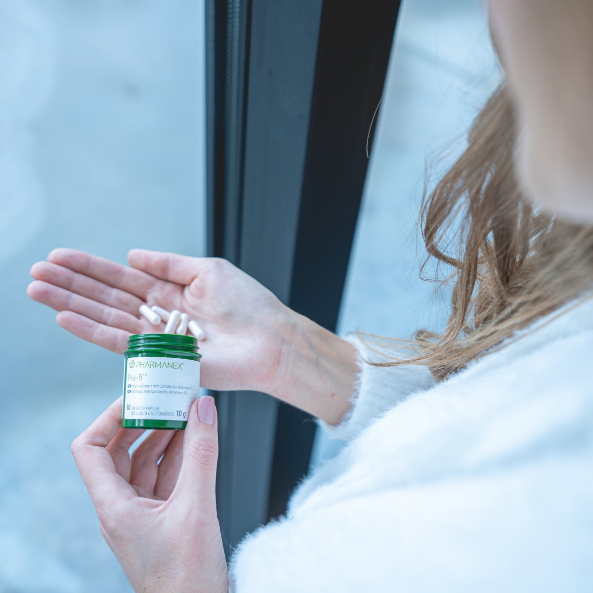 Pharmanex Pro-B pills in hand lifestyle aerial