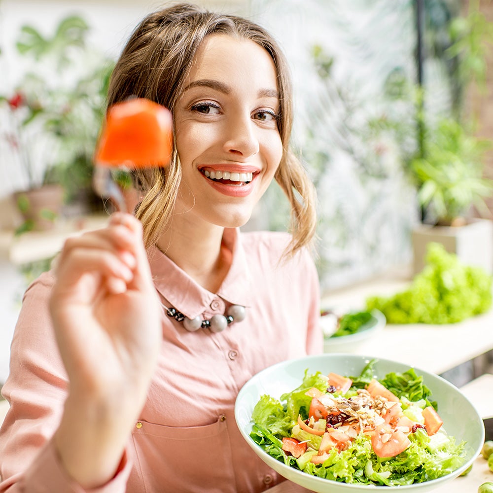 Hình ảnh người phụ nữ đang vui vẻ ăn một bữa ăn cân bằng dinh dưỡng và tốt cho sức khỏe