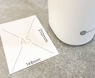 Photo of the sleek base size compared to the size of an A5 paper