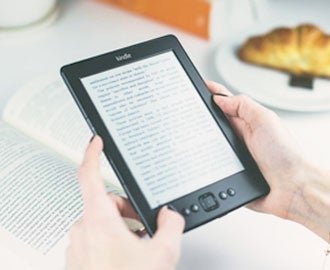 Photo of woman at home reading an article on a tablet