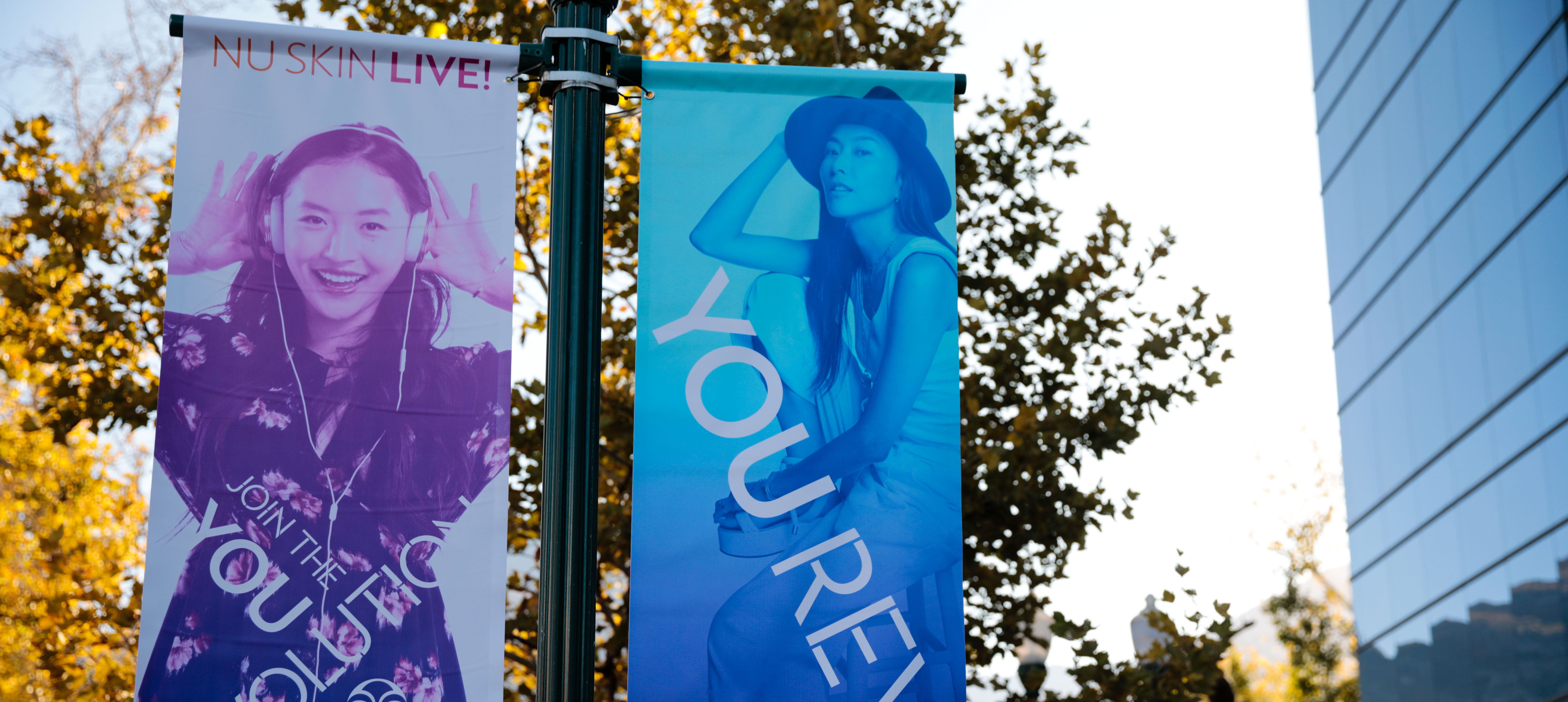 You Revolution banners hang on a light pole in front of the Nu Skin corporate office in Provo, Utah.