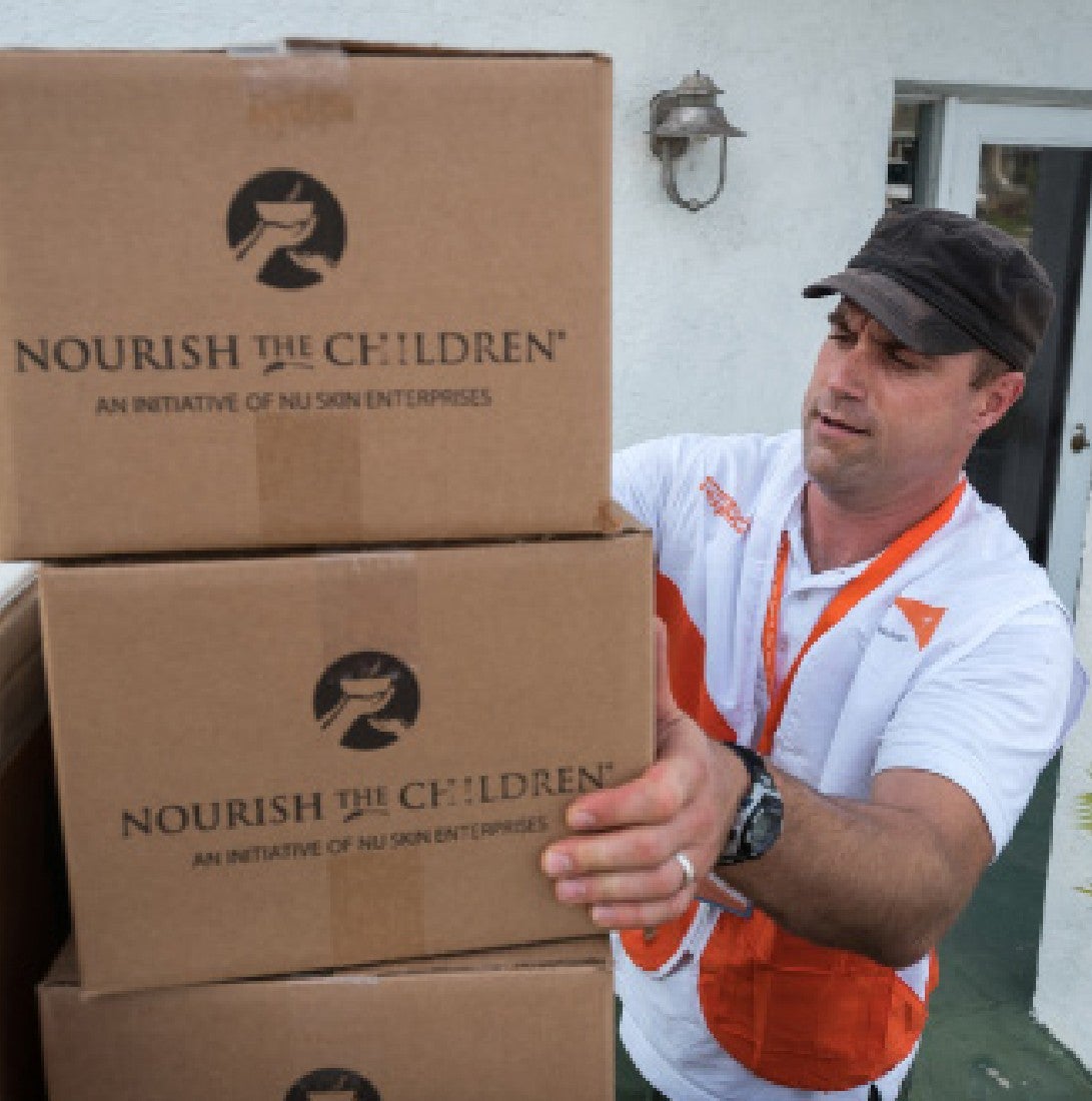 man preparing vitameal boxes for nourish the children